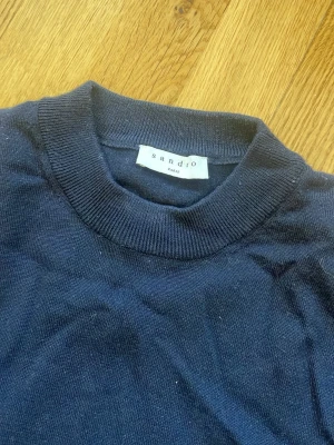 Sandra Paris merinotröja - Mörkblå merinotröja från Sandro Paris med rund halsringning och långa ärmar. Storlek medium merino ull, som ny