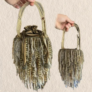 Guldig pärlbroderad handväska med fransar - Unik handväska i guldig satin med pärlbroderade fransar i guld, silver och blått. Väskan har dragskostängning och dubbla handtag täckta av pärlor. Perfekt för dig som gillar statement-accessoarer och vintagekänsla.