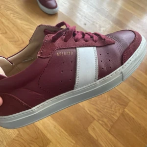 Arigato sneakers - Snygga vinröda sneakers från Axel arigato i modellen clean 90. Skorna har klassisk låg profil, matchande vinröda skosnören och vit sula. Tillverkade i slätt läder för en clean look. Ovanliga☘️🙌