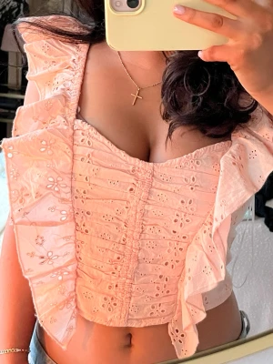 Aprikos/rosa topp - Supersöt ljusrosa/aprikos topp med broderade blommor och volangdetaljer längs axelbanden. Perfekt till sommaren🌸helt oanvänd 