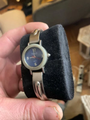 Silverfärgad analog klocka från Mango - Stilren analog klocka från Mango med rund blå urtavla och silverfärgat armband i metall. Klockan har tydliga siffror och klassisk design, perfekt för dig som gillar enkel och snygg stil. Quartz-urverk och smidig storlek på boetten.