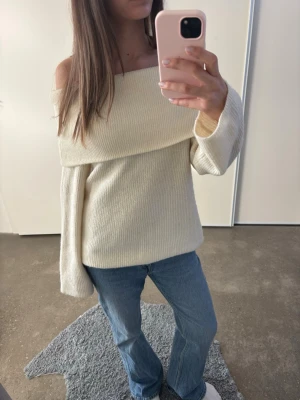 Off shoulder stickad tröja - Trendig off shoulder stickad tröja i vit. Passar dig som har storlek S/M