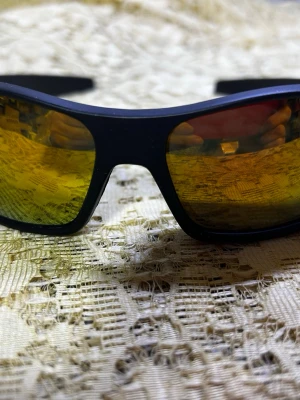 Svarta sportiga solglasögon med gula glas - Coola solglasögon med svart båge och spegelblanka gula glas. De har en sportig, svepande form som sitter tajt mot ansiktet och passar perfekt för en aktiv livsstil. Bågarna är i lätt syntetmaterial och glasen har en reflekterande finish. 155kr/st 