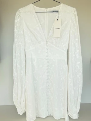 Vit blommig klänning från Adoore - Superfin vit klänning från Adoore i storlek 36, aldrig använd med prislapp kvar. 