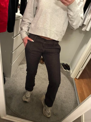 Mörkblå raka jeans med låg midja - Säljer ett par mörkblå jeans med rak passform och låg midja. Jeansen har klassiska fickor fram och bak samt hällor för skärp. Snygg minimalistisk look som passar till det mesta. Perfekta för dig som gillar en clean och enkel stil.
