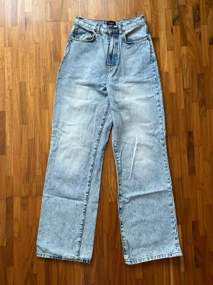 Ljusblå jeans med hög midja - Säljer ett par ljusblå jeans med hög midja. Jeansen har dragkedja och knapp framtill. Perfekta för en avslappnad och trendig stil. W28/L32. Fint skick🤗