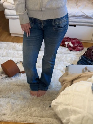 Blå lågmidjade bootcut jeans från ltb  - Säljer ett par blåa lågmidjade jeans från ltb som jag sytt ner för att få dom ännu mer lågmidjade. Dom är lite ljusare än vad som syns på bilden. Vid frågor e de bara att höra av sig. Dom är i lång 32 