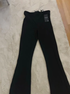 Svarta utsvängda leggings - Snygga svarta leggings med utsvängda ben och hög midja. Perfekta för en trendig och bekväm stil. Mjukt och stretchigt material som sitter skönt hela dagen. Helt nya 