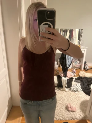 Vinröd linnetopp med v-ringning - Säljer en vinröd linnetopp med v-ringning och smala axelband. Toppen är tight och ärmlös, perfekt för att matcha med jeans eller kjol. Enkel och stilren design som passar dig som gillar en klassisk look.