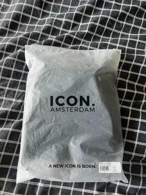 Svarta byxor från ICON Amsterdam helt oanvänd med prislapp och förpackning kvar. - Säljer ett par svarta byxor från ICON Amsterdam, modell The Silvio Trousers. Byxorna är stilrena och passar perfekt till en trendig och modern look. Materialet är troligtvis bomull eller polyester för en bekväm passform. 