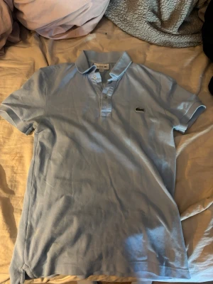 Lacoste piké  - Säljer pga används inte. Fint skick, den har legat i garderoben länge därför ser den ut som den gör tvättar och stryker innan jag skickar. Storlek xs som syns på bild men passar S. Skriv om fler bilder med bättre ljus önskas.