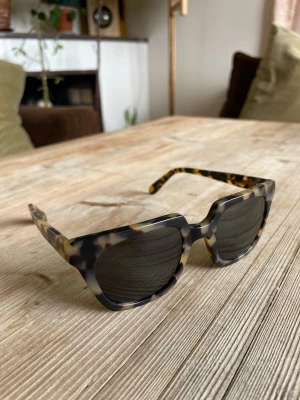 Han Kjøbenhavn - unisex sköldpaddsfärgade solglasögon dansk design - Som nya! - modell: Wolfgang färg:  Amber Tortoise (sköldpaddsmönster)  En kraftig, fyrkantig, handgjord retrobåge i högkvalitativ italiensk acetat, med en modern twist. Utrustade med mörka, reptålig Carl Zeiss-linser som ger 100 % UV-skydd.  Likt andra feminina kraftuttryckliga solglajjor från Isabel Marant, Miu miu, D&G, Carolina Herrara m.fl.  NYPRIS: 2700kr