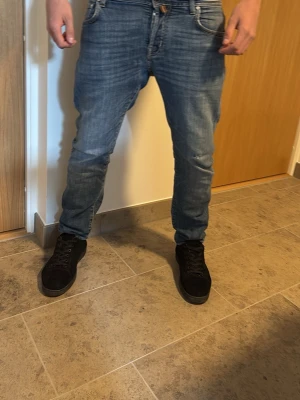 Blå jeans från Jacob Cohen - Snygga blå jeans från Jacob Cohen med klassisk femficksdesign och raka ben. Jeansen har en diskret tvättad look och läderpatch med logga bak i midjan. Tillverkade i denim med en skön passform som sitter bra på höften. Pris kan diskuteras 