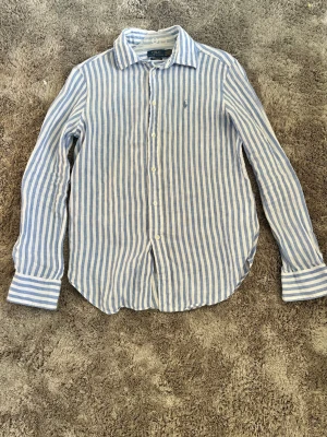 Linneskjorta fårn Ralph Lauren  - Säljer en Ralph Lauren skjorta då den är för liten. Den är sparsamt använd och mycket bra skick. Skulle säga ifall du är lite under 160 så passar den fint 