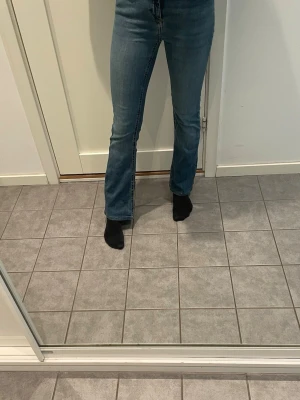 Blå bootcut jeans med klassisk tvätt -  Hitta ditt nya go to-plagg för både jobb och lek med ett par coola jeans i perfekt passform och färg. Tillverkad av högpresterande, extrastretchiga tyger för en ny nivå av feelgood-komfort. Har en medelhög midja - Tvätt/finish : Skonsamt tvättad, mörk denimlook - Passform : Dessa jeans med utsvängda passform kramar om dina höfter och lår och vidgar sig från knäet. Ordinarie pris: 550 kr. Jag är 162 cm lång och bär storleken XS 30 + att de är ca 1,5 cm uppsydda.