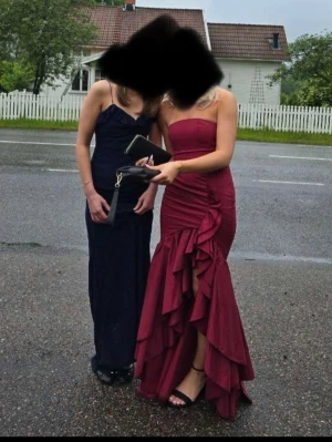 Vinröd axelbandslös långklänning - Säljer nu min fina balklänning då den inte kommer till användning, den är använd en gång så den är i mycket bra skick. Den är ifrån Babyboo och är i str Xs. Skriv om ni vill ha mer bilder eller undrar något❣️
