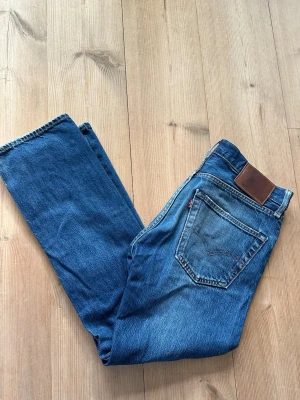 Levi's jeans 501 - Klassiska 501 Levi's jeans med rak passform och fem fickor. Jeansen har slitningar och en trasig detalj vid myntfickan vintage look. Storlek: W31 L30