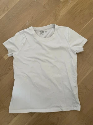 Vit basic t-shirt från Basic You - En enkel och stilren vit t-shirt från Basic You i ekologisk bomull. Klassisk rund halsringning och korta ärmar. Perfekt till alla outfits och superbekväm tack vare det mjuka materialet.