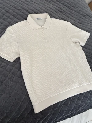 Vitbeige polotröja - Vitbeige polotröja från Zara med en klassisk krage och en diskret dragkedja framtill. 