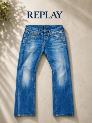 Blå raka jeans från Replay - Snygga blå jeans från Replay med raka ben och klassisk femficksmodell. Jeansen har slitningar och ljusa partier framtill och baktill för en trendig look. Tillverkade i denim med detaljerade sömmar och läderpatch bak i midjan.  Skriv om du vill ha mått.
