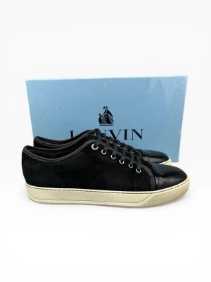 Lanvin Cap Toe Sneakers – Svart | Strl 41 | Mycket Gott Skick - Lanvin Cap Toe i klassisk svart — ikonisk fransk lyx i mycket gott skick med minimalt slitage. Signatur cap toe design och premium läder som håller i många år till. Storlek 41. Kan även köpas via vår hemsida www.nordens.store med Klarna & Paypal 😊 📦 Spårad frakt, väl förpackad.