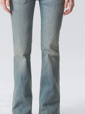 Ljusblå bootcut jeans från Weekday - Säljer ett par ljusblå bootcut jeans från Weekday med klassisk femficksdesign och hög midja. Jeansen har en lätt tvättad look och är tillverkade i denim med lite stretch för skön passform.