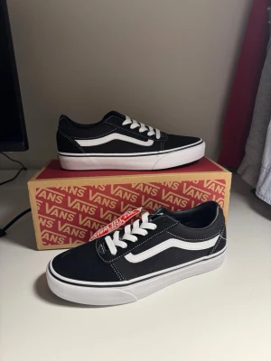 Vans Old Skool – Svarta/Vita – Nya med kartong - Säljer ett par klassiska Vans Old Skool i svart/vitt. Helt oanvända – endast provade. Kommer med originalkartong. Perfekta för både vardag och stilren streetwear-look.  Skick: Nytt (oanvända) Storlek: 37, US 5.5, UK 4.5 Färg: Svart/vit Märke: Vans  Detaljer:  * Ikonisk sidostrimma * Vita skosnören * Gummisula med bra grepp * Låg modell