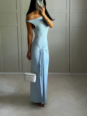 Ljusblå offshoulder långklänning - Trendig eftertraktad ljusblå långklänning med offshoulder-design och snygg slits framtill. Klänningen har en åtsittande passform och draperad detalj vid midjan som ger en cool look. Köpt på ginatricot 