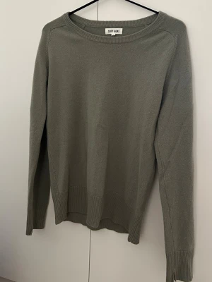 Khakigrön kashmirtröja Soft Goat stl. S - En khakigrön kashmirtröja från Soft Goat med rund halsringning och långa ärmar. Storlek S. Använd ett fåtal gånger. 