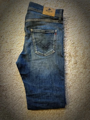 Replay jeans - Säljer nu dessa jeans från Replay. Jeansen har en fin färg perfekt inför sommaren☀️. Jeansen är i mycket bra skick och använd endast ett fåtal gånger. Måtten är 40cm midja och 100cm längd. (Passar ungefär W30) Annars är jeansen i storleken 16y. Nypris är runt 1200kr. Mitt pris 399kr. Skriv gärna vid frågor! 