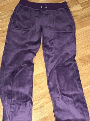 Lila velourmjukisbyxor Juicy Couture - Lila juicy couture byxor i storlek s, säljs då de ej används. Saknar snöre, men är i speciell färg som få har