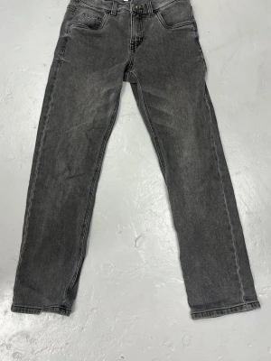 Grå raka jeans från LAB Industries - Snygga grå jeans från LAB Industries med rak passform och klassisk femficksdesign. Jeansen har en tvättad look och är tillverkade i denim med en skön känsla. Perfekta för en avslappnad och trendig stil. Gummiband i midjan för att justera passformen.