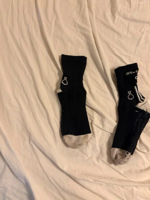 Svarta Nike strumpor med grå tå - Ett par svarta strumpor från Nike med grå tå och häl. Strumporna har vit Nike-logga och detaljer på sidan. Perfekta för dig som vill ha bekväma och sportiga strumpor till vardags eller träning.