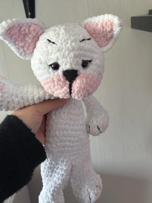 Virkad vit och rosa katt/hund - Supergullig handvirkad katt/hund i mjukt garn, vit med rosa detaljer på öron och kinder samt svarta broderade detaljer. Perfekt som present eller mysig dekoration. Katten/hunden har stora öron och söta ögon som ger den ett charmigt uttryck.
