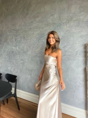 Balklänning - Jättefin axelbandslös satin klänning i lite cremefärg, i strl XS ifrån Billy J och i nyskick. Heeeelt perfekt till balerna nu💕💕💕💕                                                                                    (Första bilden är lånad för att kunna visa bättre)☺️☺️