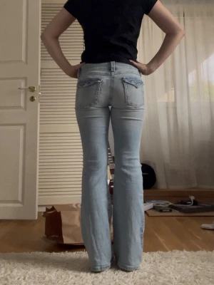 Lågmidjade bootcut jeans med hål - Jättesöta och bekväma jeans med hål. Är storlek 158 men sitter som 34/XS. De är stretchigt material så jättesköna att ha på sig 💕 De är perfekta i längd för mig som är 164 cm. De har vissa defekter som en påsydd lapp som jag själv inte tänker på så mycket (bild 3). Har dessutom en sminkfläck på benet från tidigare ägaren som jag inte försökt få bort. 
