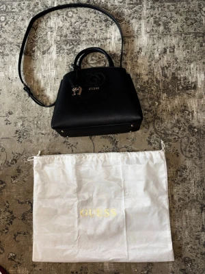 Äkta guess väska med dustbag i nyskick - Jag säljer min fina guess väska som jag köpte för två veckor sen. Jag säljer endast pgra att jag egentligen inte hade råd. Jag säljer den för halva priset så passa på. Du får med dustbag. 