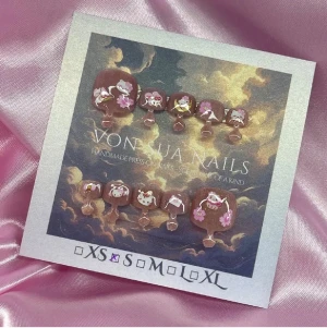 Kitty (S) Square-Toes - Handgjorda toe- press-on naglar i rosa cateye färg med söta (HK) kattmotiv och rosa detaljer. Naglarna har en kort, rund form och är dekorerade med små blommor och figurer. Perfekt för dig som vill ha unika och kreativa tånaglar. Storlek S: 14 mm, 9 mm, 9,5 mm, 9 mm, 6 mm.