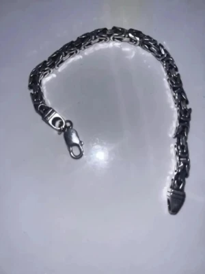 Silverfärgat kedjearmband - Snyggt armband i silverfärgad metall med robust kedjedesign och karbinhake. Armbandet har en stilren och tidlös look som passar perfekt till många olika stilar. Perfekt accessoar för dig som gillar detaljer i metall.