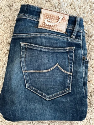 jacob cohen jeans  - Snygga mörkblå jeans från jacob cohen femficksdesign och kontrastsömmar. Jeansen har en rak passform och är tillverkade i slitstarkt denim-material. Märkespatch med J på bakfickan ger en cool detalj. skick är 8/10 