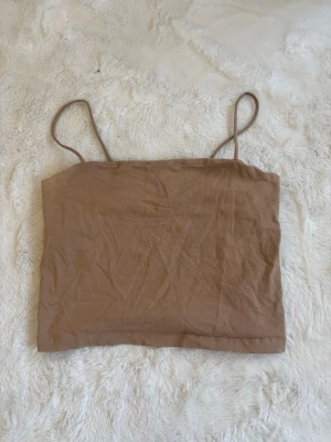 Beige linnetopp från Gina Tricot stolek L  - Snygg beige linnetopp från Gina Tricot med tunna axelband och enkel, croppad passform. Perfekt att styla med jeans eller kjol för en chill look. Tillverkad i mjuk bomull som känns skön mot huden. Pris kan diskuteras 