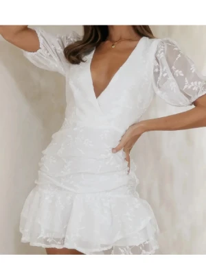 SÖKER Vit kort omlottklänning med volang - SÖKER denna klänning. Hör av er ifall ni vill sälja🥰