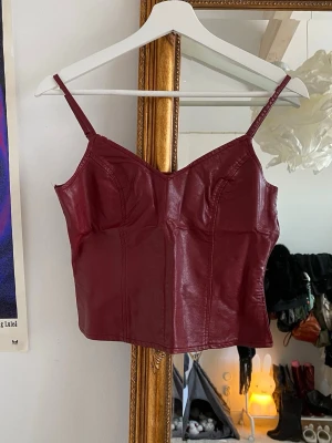 Vinröd läder skinn topp  - Köpt på vinted, originellt från missguided. Dragkedjan är trasig så jag har satt dit hakar 
