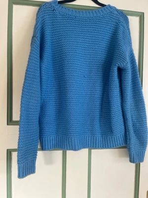 Blå stickad tröja från Bik Bok - Mysig blå stickad tröja från Bik Bok i storlek XS. Tröjan har en klassisk rund halsringning, långa ärmar och ribbstickade muddar vid ärmslut och nederkant. Perfekt för lager-på-lager och enkel att matcha med jeans eller kjol. Passar även S 