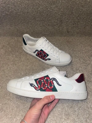 Gucci ace kingsnake - Hej! Säljer nu mina Gucci Ace "Kingsnake" sneakers. Storlek 9 (motsvarar ca 43). Mycket bra skick (8.5/10), välvårdade med fint läder och helt broderi. Nypris ca 8200 kr, säljs nu för 2199 kr då box och dustbags tyvärr inte finns kvar. En av Guccis mest ikoniska modeller. Passa på att fynda!