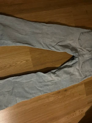 Ljusblå bootcut jeans - Säljer ett par ljusblå bootcut jeans från ginatricot i klassisk denim med fem fickor och dragkedja. Jeansen har en avslappnad passform och lätt utsvängda ben. Perfekta till en casual look och enkla att matcha med olika stilar.