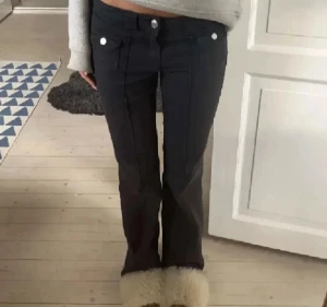 Svarta bootcut jeans med silver knappar H&M - Säljer ett par svarta bootcut jeans med silver knappar och fickdetaljer fram. Jeansen har låg midja och markerade sömmar som ger en snygg retrovibe. Perfekta för dig som gillar en trendig och avslappnad stil. Säljer dessa jeans då de tyvärr ej passade på mig! Skriv gärna om du vill se egna bilder på jeansen eller pruta ner på priset! Djur och rökfritt hem💕