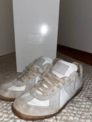 Maison margielas  - Maison Margiela i vitt, storlek 45. Stilren och exklusiv design med högkvalitativa material och bekväm passform. Skorna är i bra skick och har tagits väl om hand. Box och shoe bags ingår. Skorna rengörs noggrant innan leverans.