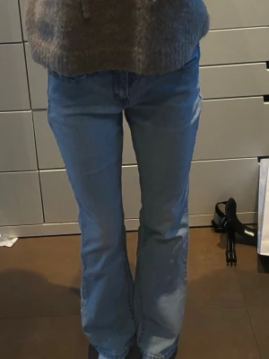 Ljusblå bootcut jeans från Levi's - Säljer ett par ljusblå jeans från Levi's med bootcut passform och klassiska detaljer som kontrastsömmar och den ikoniska röda Levi's-lappen på bakfickan. Jeansen har normal midja och är tillverkade i mjukt denimtyg. Perfekta för en avslappnad och trendig look.