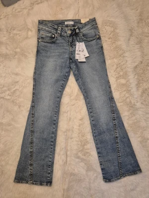 Blå bootcut jeans från Gina Tricot. HELT NYA MED ETIKETTER KVAR! - ✨ Nya Y2K twisted petite boot jeans – oanvända med etikett ✨  Säljer ett par helt nya jeans då de blev för korta för mig.  • Storlek 36 • Mid blue (ljusblå) • Låg midja, figurnära passform • Lätt utsvängda ben • Stretchigt material • Broderade bakfickor • OCS Blended-certifierade  Nypris 499 kr, säljes för 480 kr (pris kan diskuteras vid snabb affär).  Skick: Helt nya. Hör av dig vid intresse!